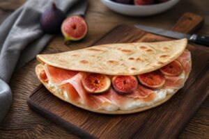 Piadina croccante con prosciutto crudo, fichi freschi tagliati e squacquerone di Romagna, servita su tagliere di legno con rucola